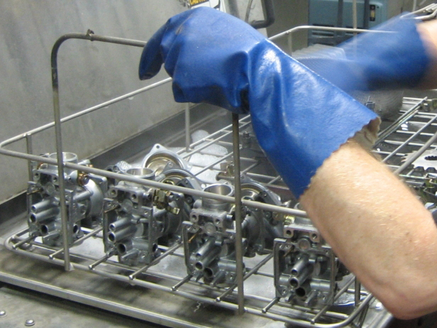 Ultrasonically cleaning carburetors as part of rebuilding